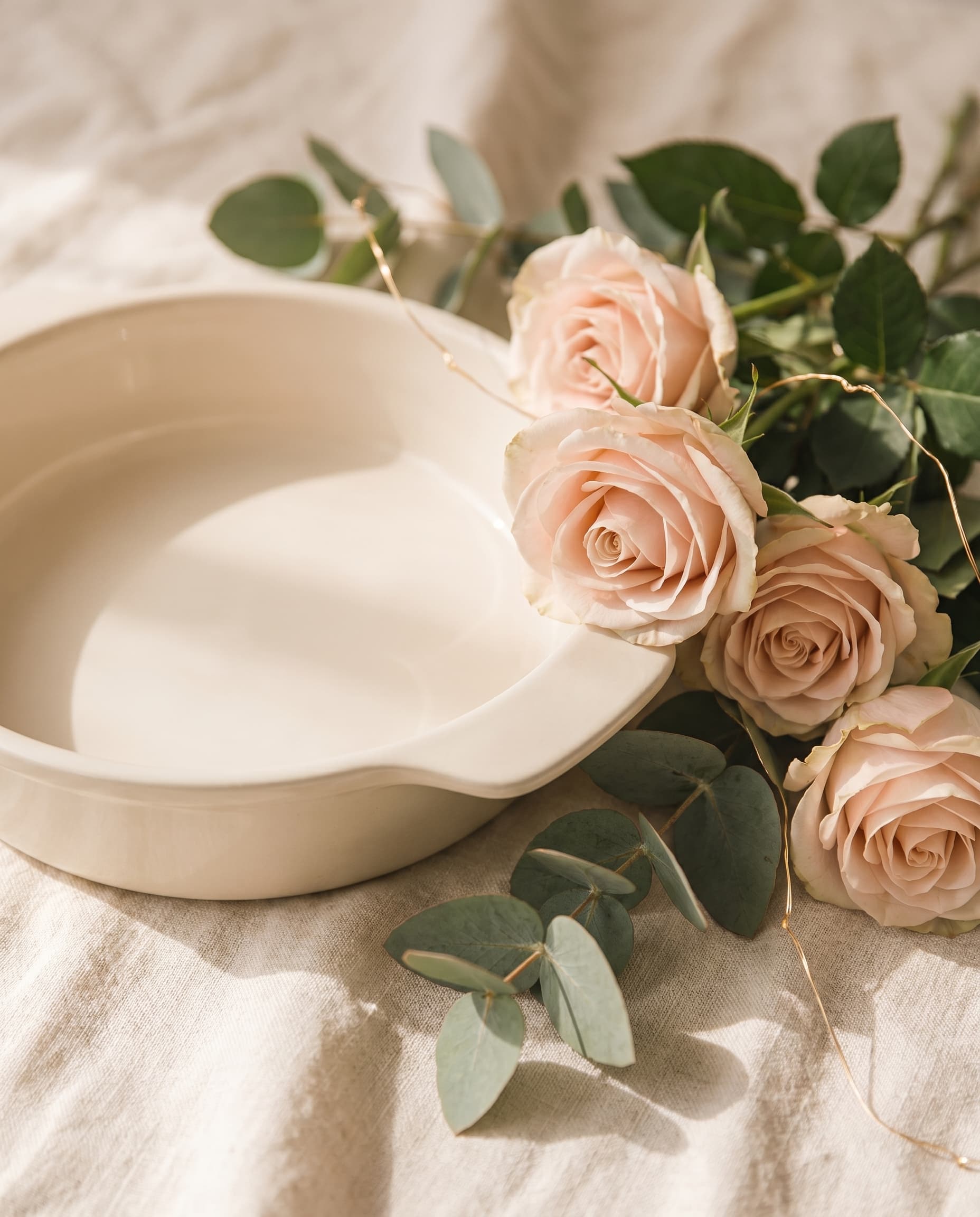 A cream SMEG ceramic keepsake dish styled with soft roses and eucalyptus
